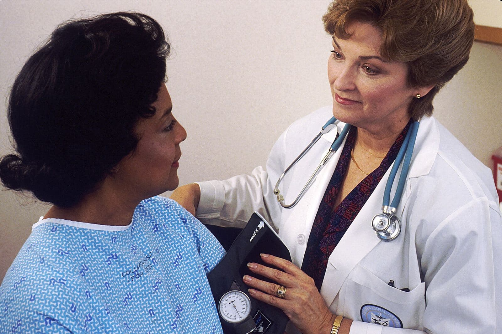 A doctor takes a patient's blood pressure during a consultation